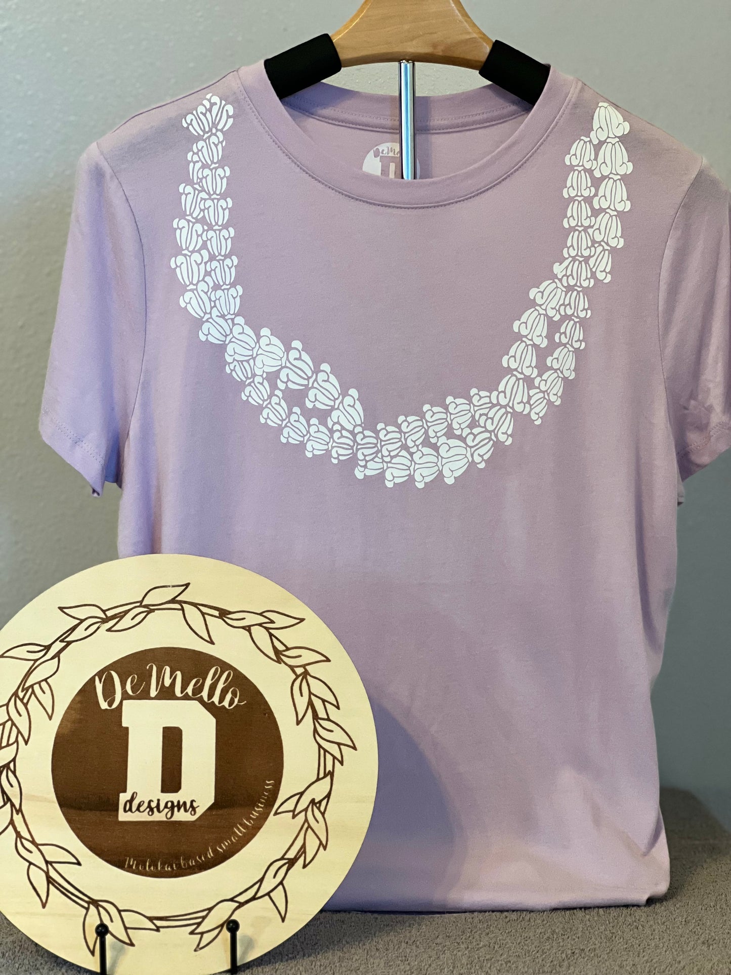 White crown lei on lilac tee